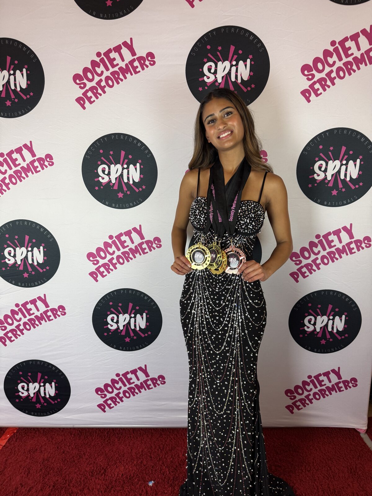 AOS student Anika Kumar holding her SPiN awards